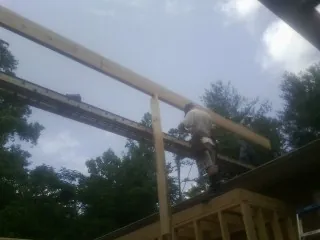 Carpenter setting a ridge beam over a new addition frame — Ice Dam Removal by Roofing Brothers in Sharpes
