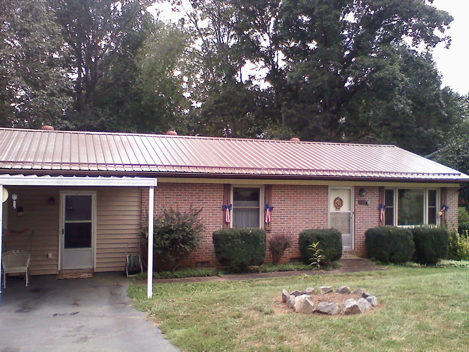 Bronze metal roof and carport on a brick ranch home — Roof Repair work by our crew in Sharpes